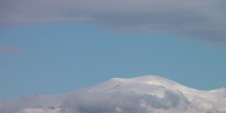 Slightly cloudy skills floating over mountains